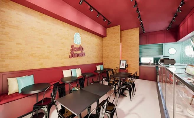O salão da Padaria Café da Santa Janela, com as mesas encostadas na parede de tijolo.